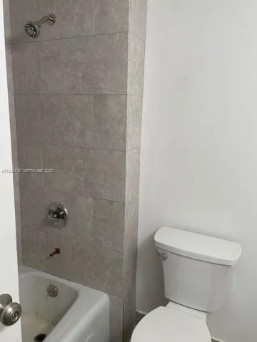 a white toilet sitting next to a bath tub