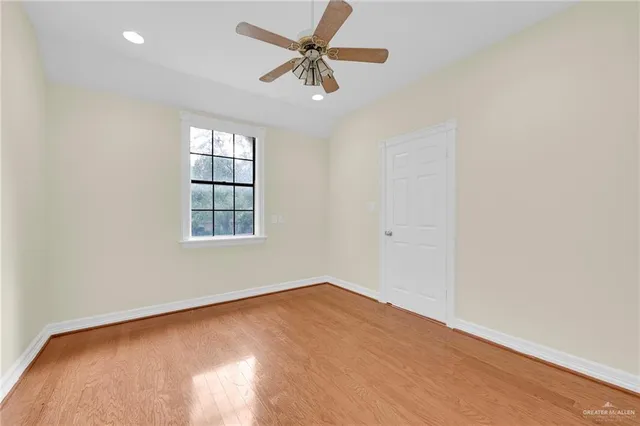 an empty room with a window and a fan