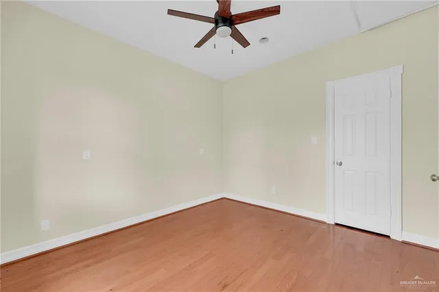 a view of a room with wooden floor and ceiling fan