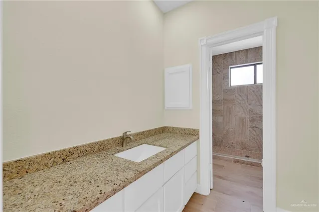 a bathroom with a granite countertop sink and vanity