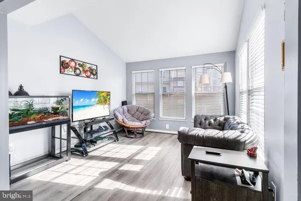 a living room with furniture a flat screen tv and a table