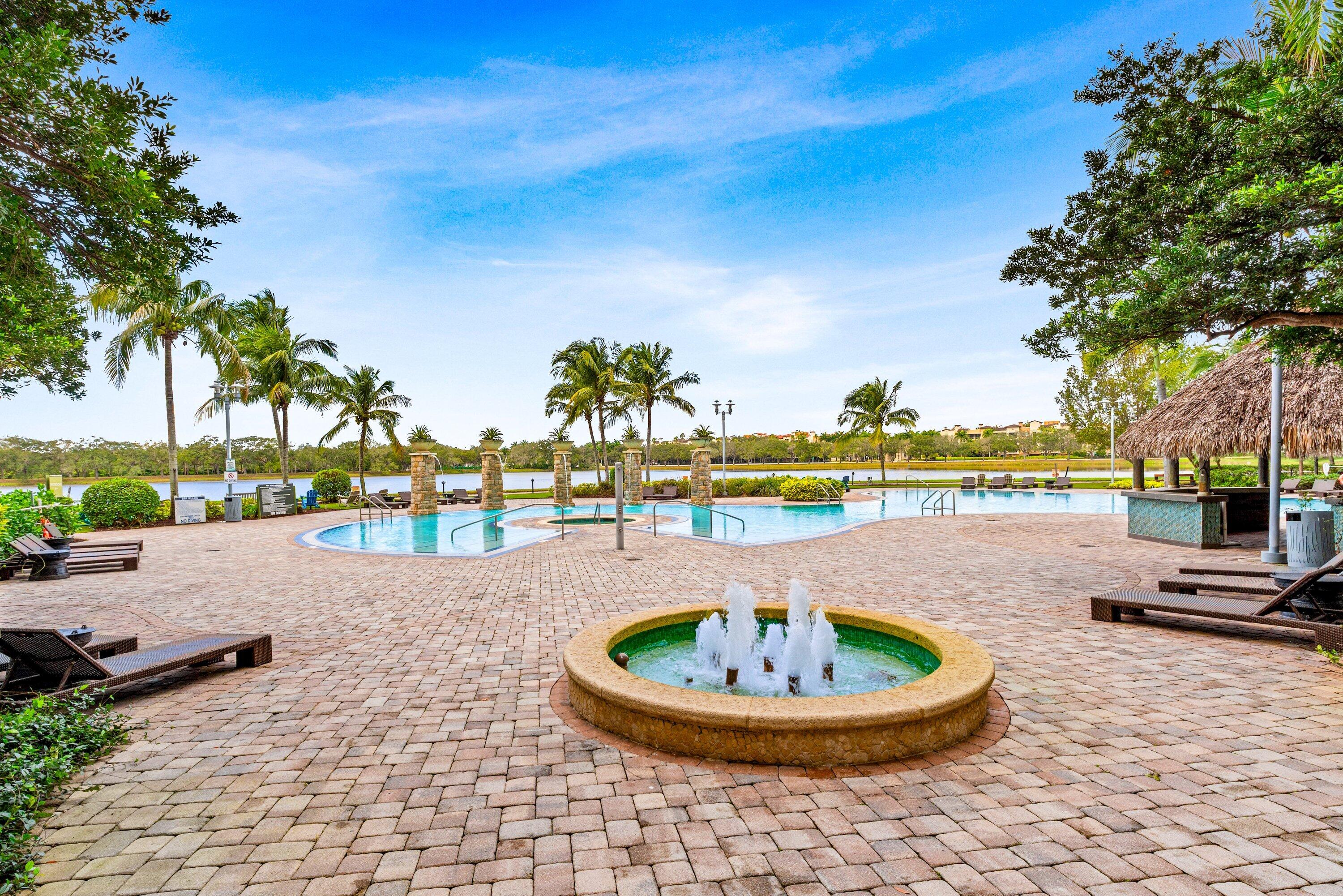 2641 North Flamingo Road, Unit 2701N Sunrise, FL 33323 - Photo 27 of 38 a view of a swimming pool with a lawn chairs and a fire pit