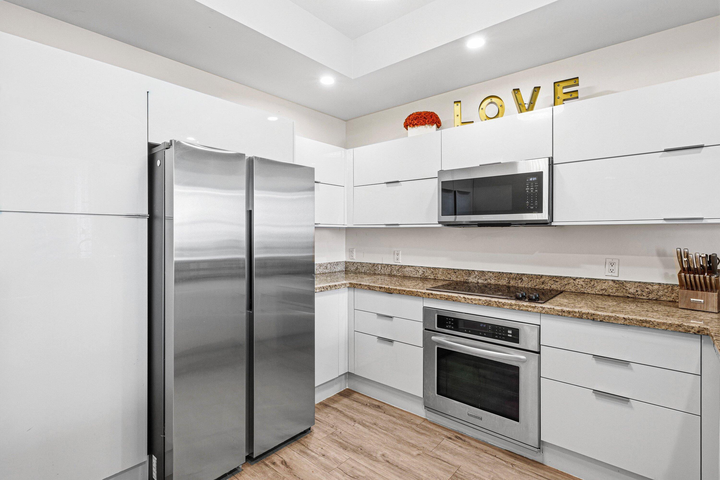 2641 North Flamingo Road, Unit 2701N Sunrise, FL 33323 - Photo 8 of 38 a kitchen with stainless steel appliances granite countertop a refrigerator and a microwave