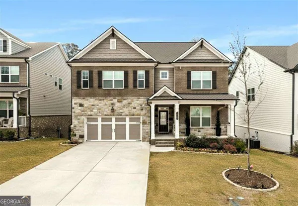 a front view of a house with yard and garage
