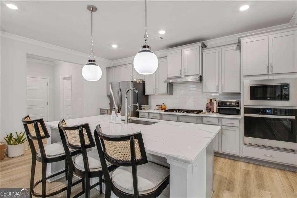 338 Ryston Way Grayson, GA 30017 - Photo 18 of 61 a kitchen with a dining table chairs and white cabinets