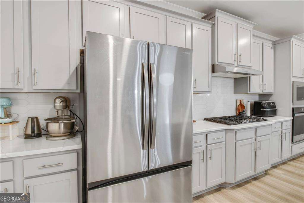 338 Ryston Way Grayson, GA 30017 - Photo 19 of 61 a kitchen with stainless steel appliances a refrigerator sink and cabinets