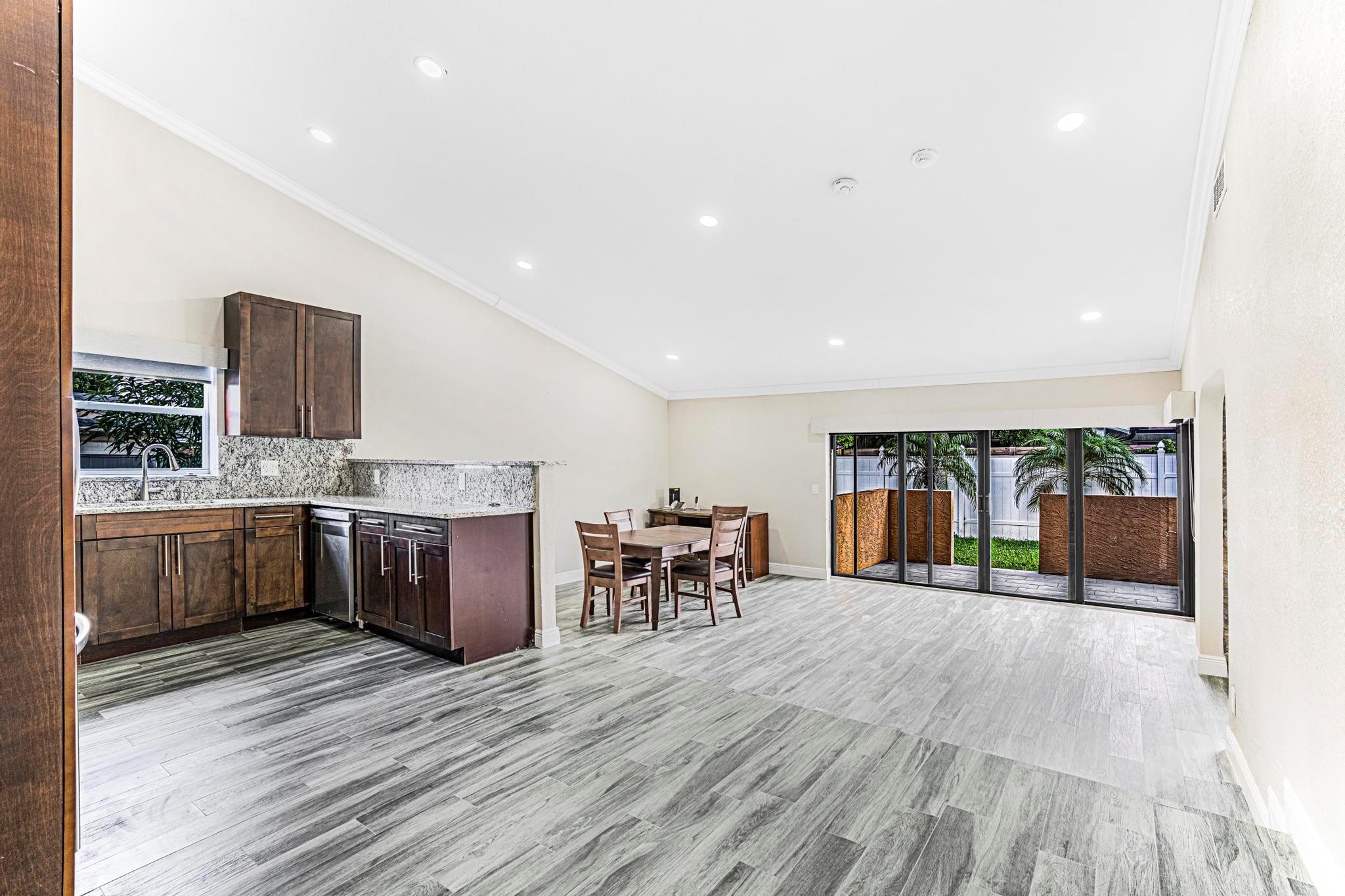 3374 Northwest 27th Terrace Boca Raton, FL 33434 - Photo 12 of 33 a kitchen with stainless steel appliances kitchen island granite countertop a refrigerator and cabinets
