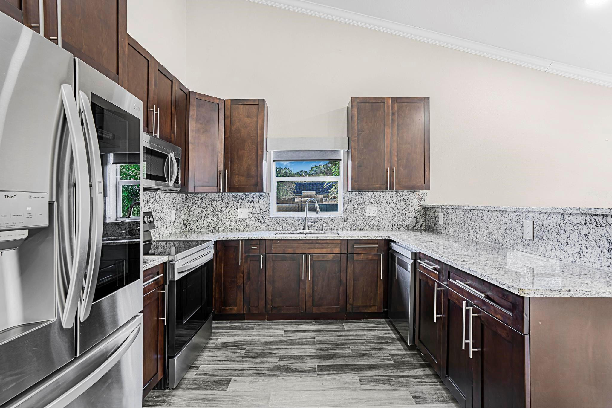 3374 Northwest 27th Terrace Boca Raton, FL 33434 - Photo 14 of 33 a kitchen with stainless steel appliances granite countertop a sink stove and refrigerator