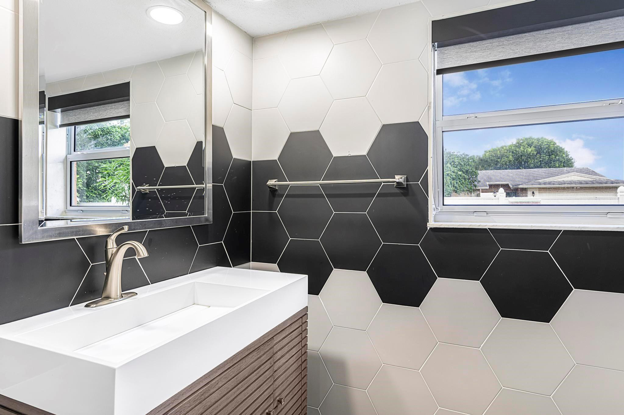 3374 Northwest 27th Terrace Boca Raton, FL 33434 - Photo 24 of 33 a bathroom with a double vanity sink a toilet and a window