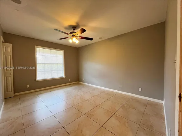 an empty room with windows and fan