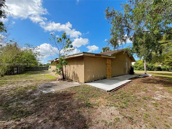a view of a house with backyard and tree
