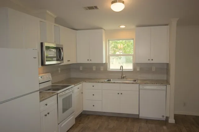 a kitchen with white cabinets and white appliances