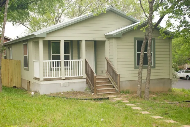 a view of a house with backyard and a tree