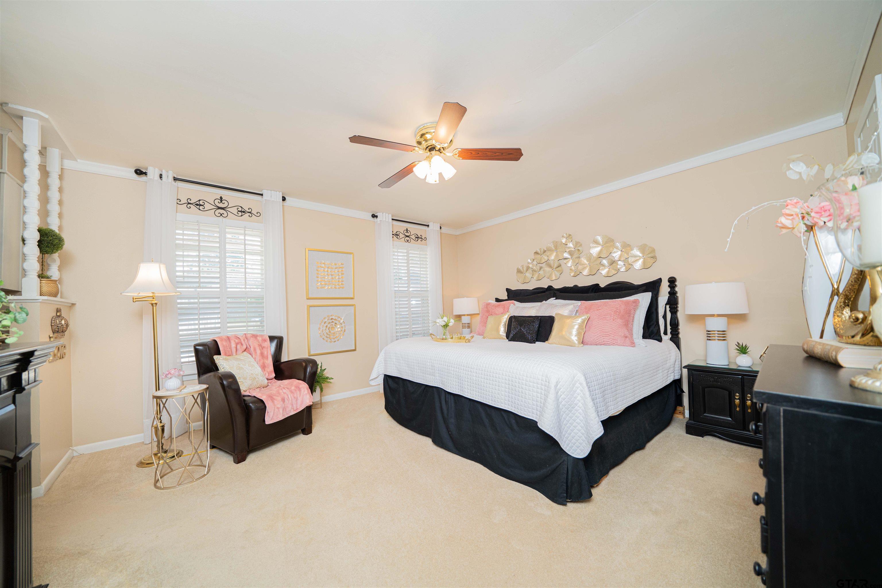 209 Cheryl Street Longview, TX 75604 - Photo 14 of 41 a spacious bedroom with a bed chandelier and a window