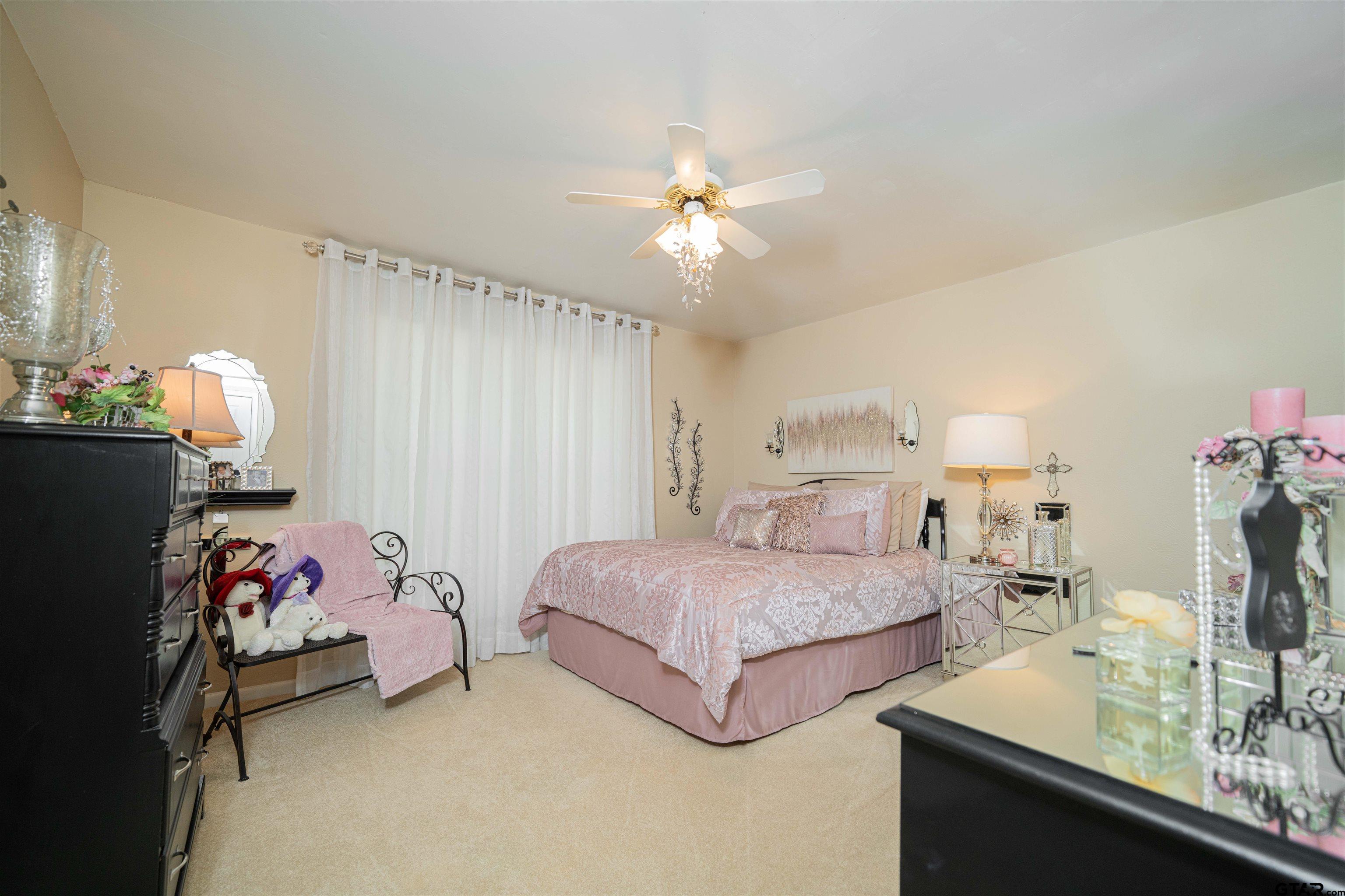 209 Cheryl Street Longview, TX 75604 - Photo 19 of 41 a bedroom with a bed and a chandelier