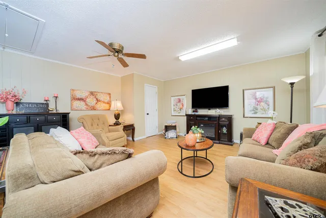a living room with furniture and a flat screen tv with wooden floor