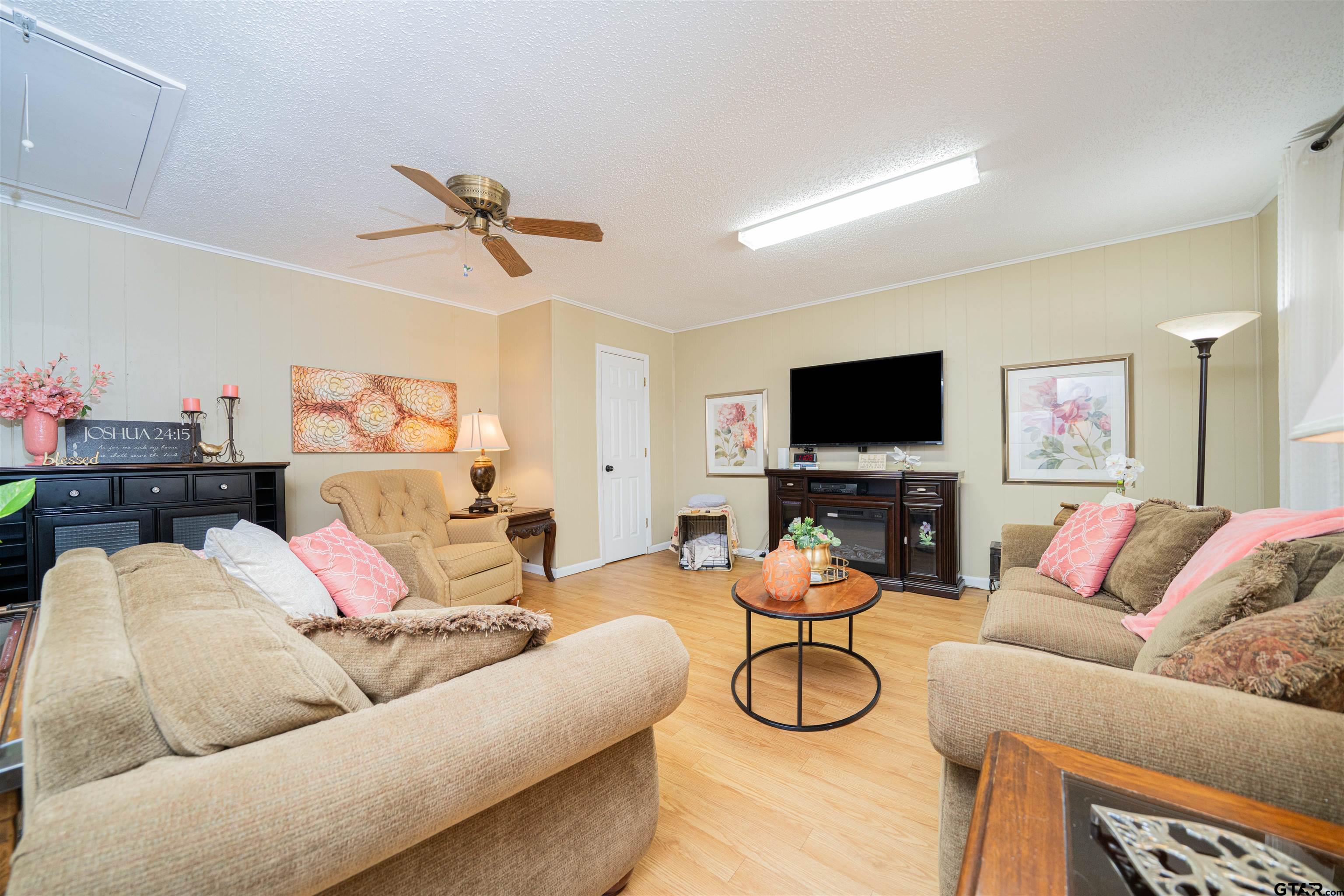 209 Cheryl Street Longview, TX 75604 - Photo 23 of 41 a living room with furniture and a flat screen tv with wooden floor