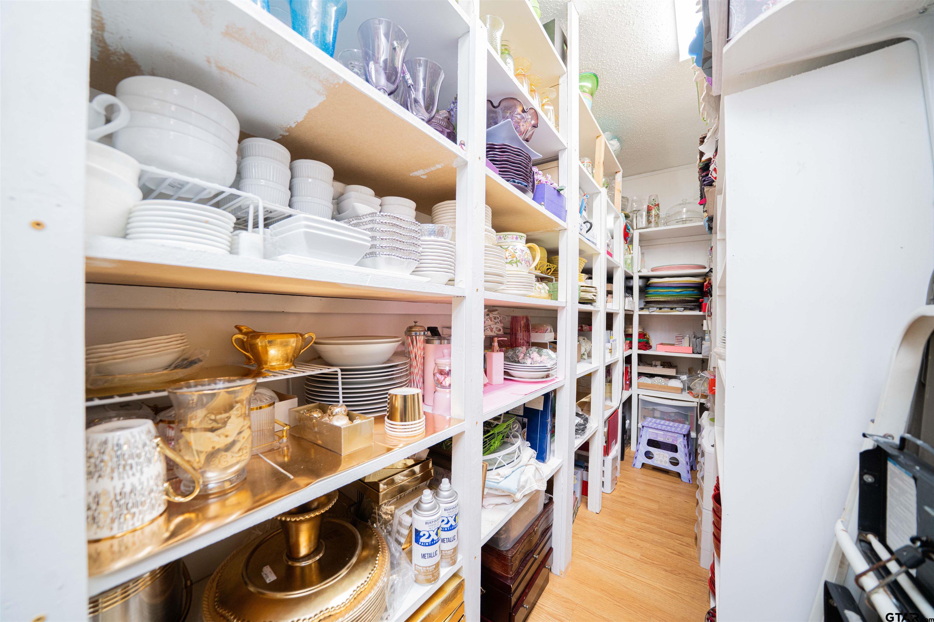 209 Cheryl Street Longview, TX 75604 - Photo 25 of 41 a close view of walk in closet with clothes and shoes