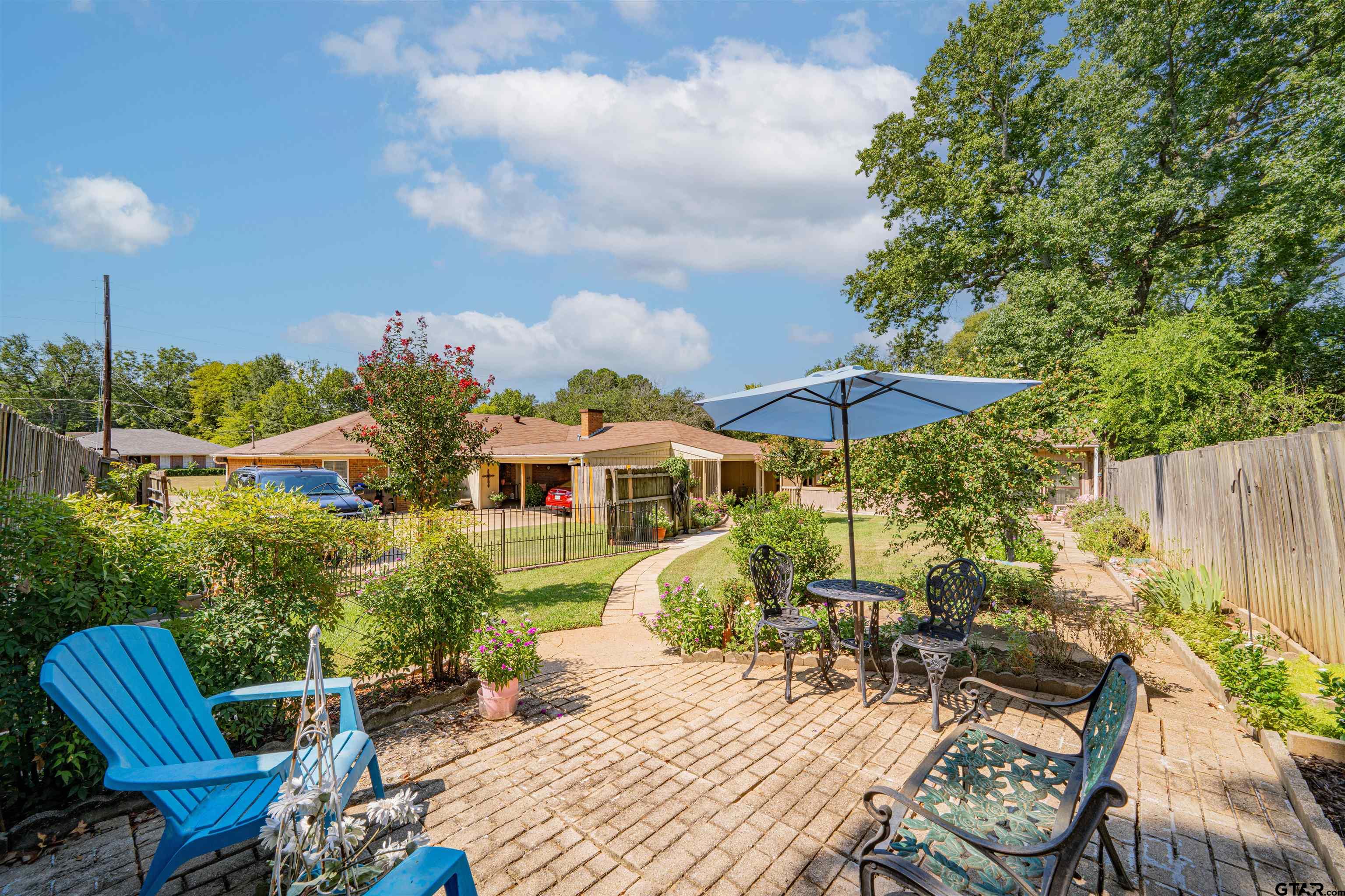209 Cheryl Street Longview, TX 75604 - Photo 35 of 41 a view of a patio with table and chairs under an umbrella