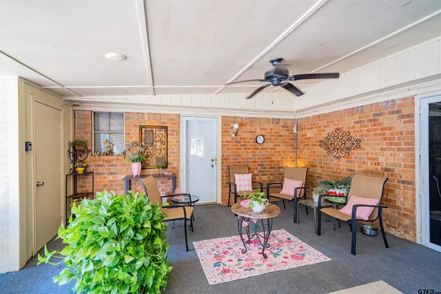 a living room with patio furniture and a potted plant