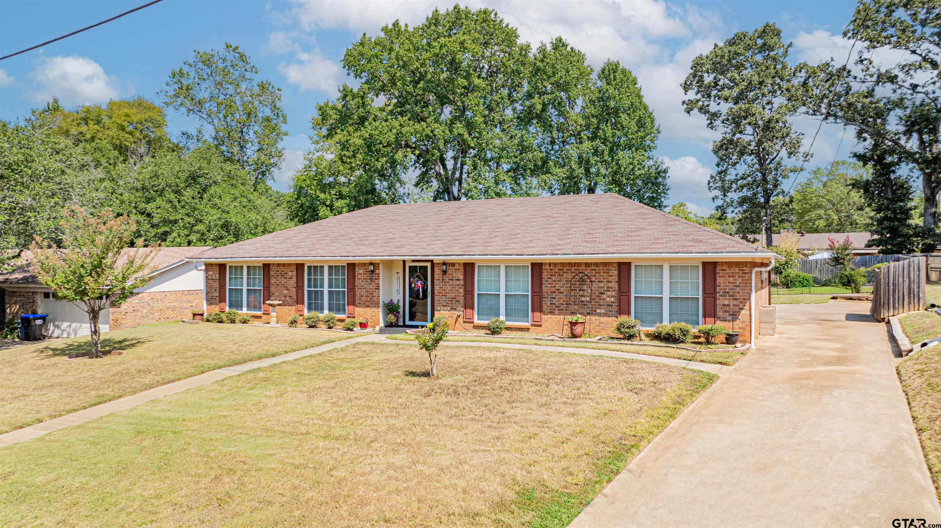 209 Cheryl Street Longview, TX 75604 - Photo 39 of 41 a backyard of a house with table and chairs under an umbrella