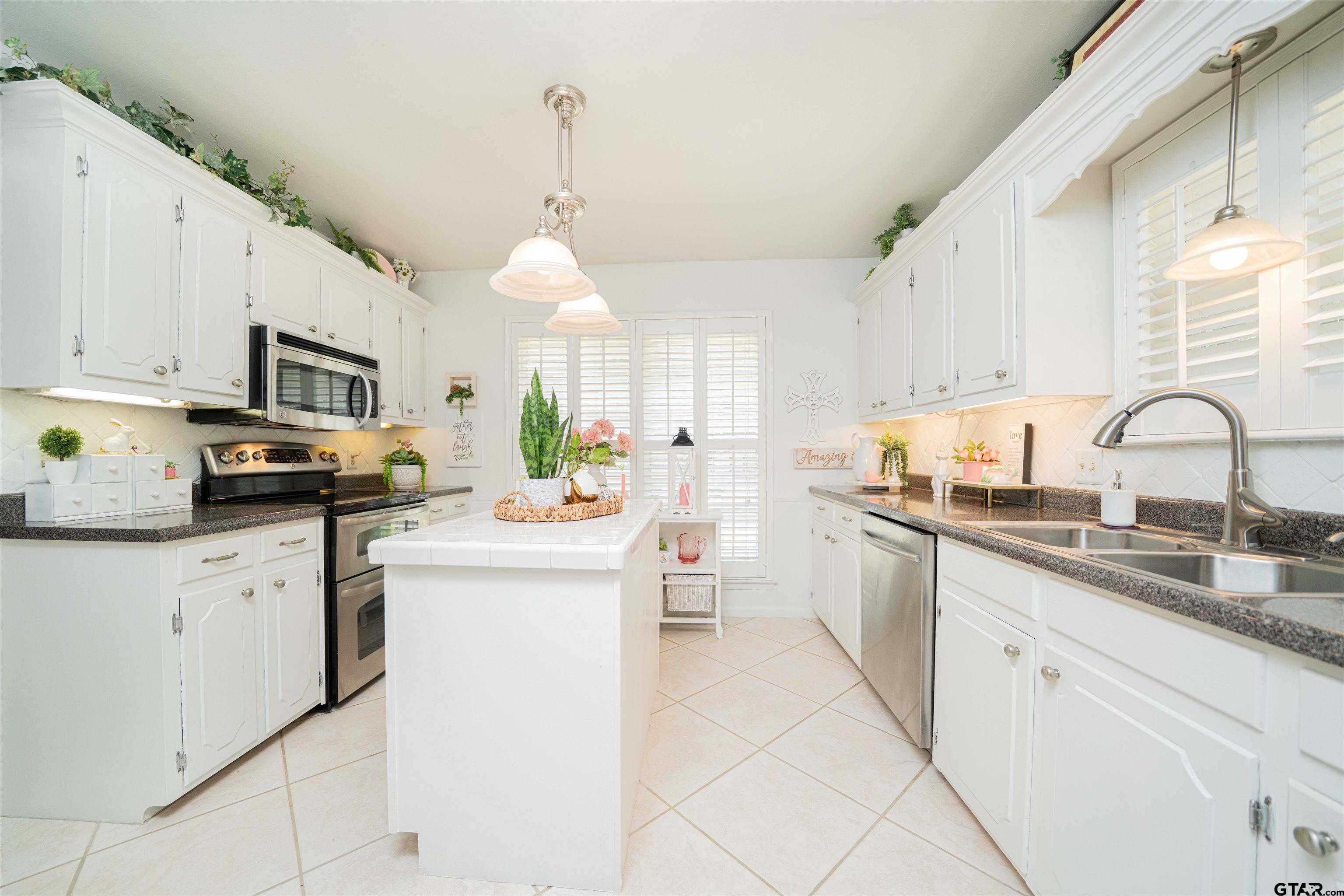 209 Cheryl Street Longview, TX 75604 - Photo 4 of 41 a kitchen with granite countertop white cabinets and white appliances