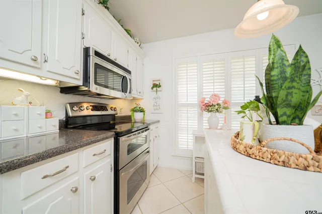 a kitchen with stainless steel appliances granite countertop a stove a sink and a white cabinets