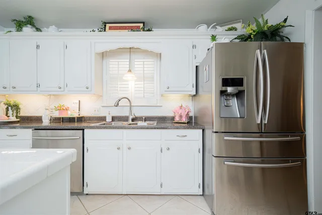 a kitchen with stainless steel appliances a refrigerator sink and cabinets