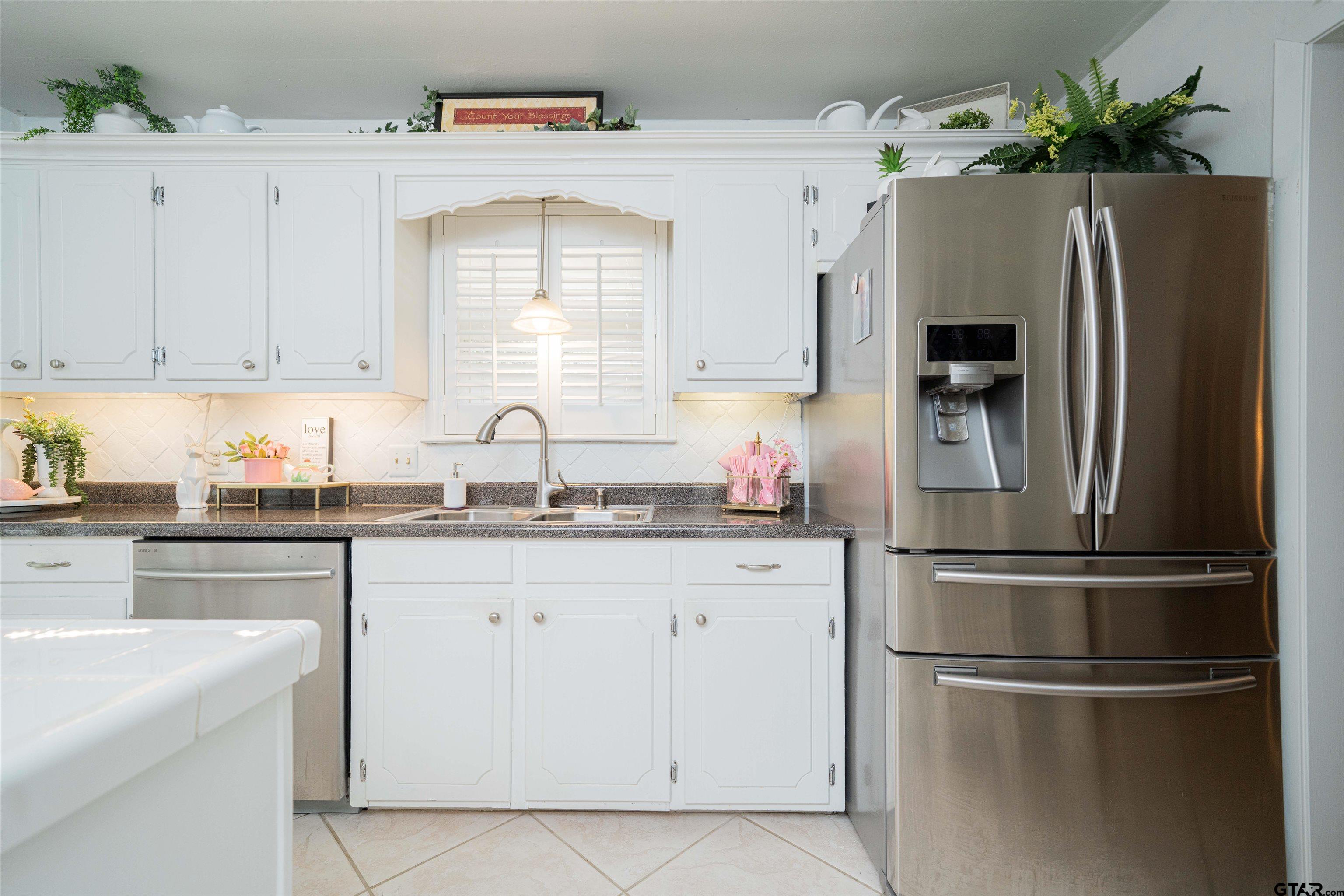 209 Cheryl Street Longview, TX 75604 - Photo 8 of 41 a kitchen with stainless steel appliances a refrigerator sink and cabinets