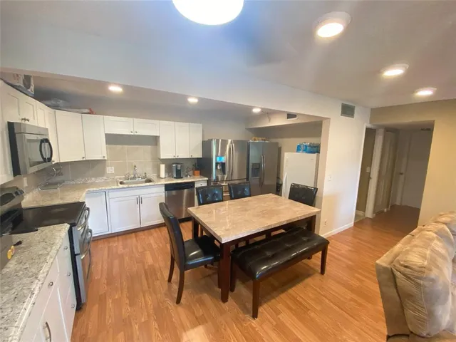 a large kitchen with a table and chairs