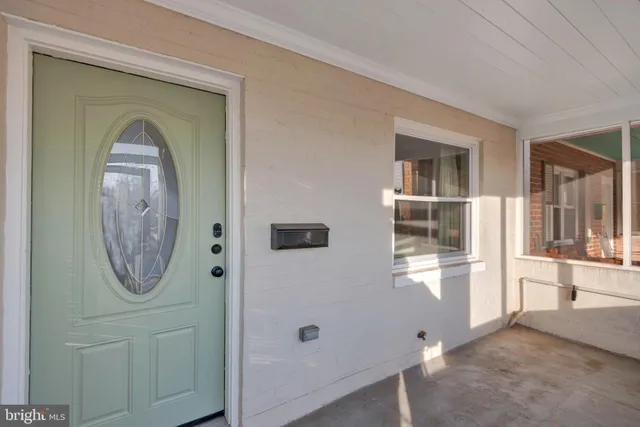 an entryway with wooden floor mirror and windows