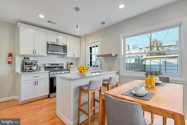 a kitchen with a sink a stove and chairs