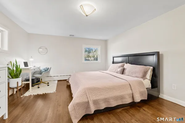 a bedroom with a bed and wooden floor