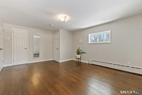 a view of an empty room with wooden floor