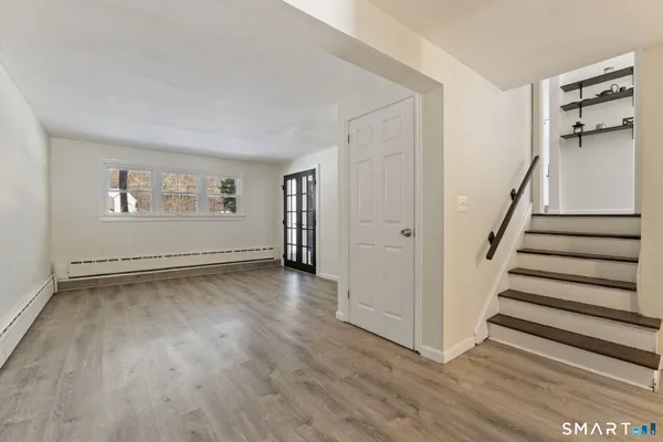 a view of a room with wooden floors and white walls