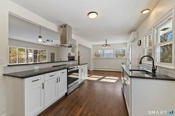 a kitchen with granite countertop a sink stainless steel appliances and cabinets