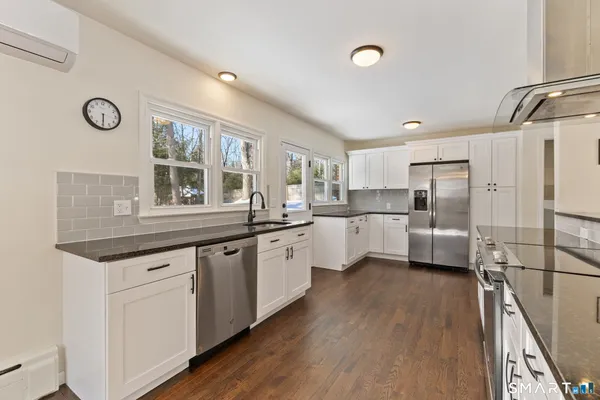 a kitchen with white cabinets and white appliances