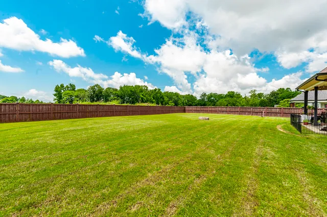 a living room with furniture a ceiling fan a rug and a window