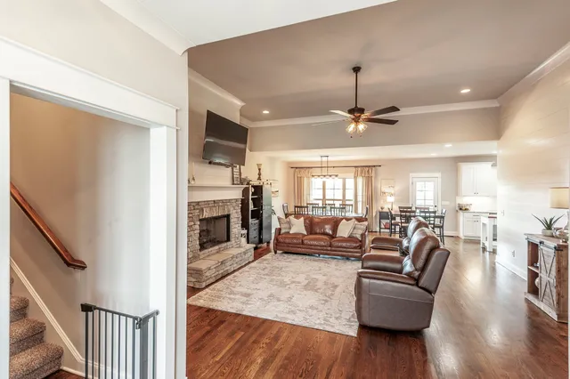 a view of a dining room and livingroom with furniture wooden floor a chandelier