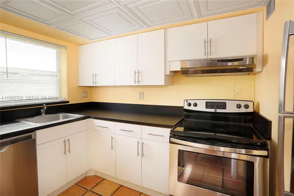 a kitchen with a sink stove and cabinets