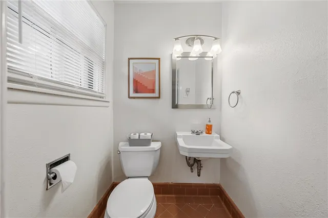 a bathroom with a sink mirror and toilet