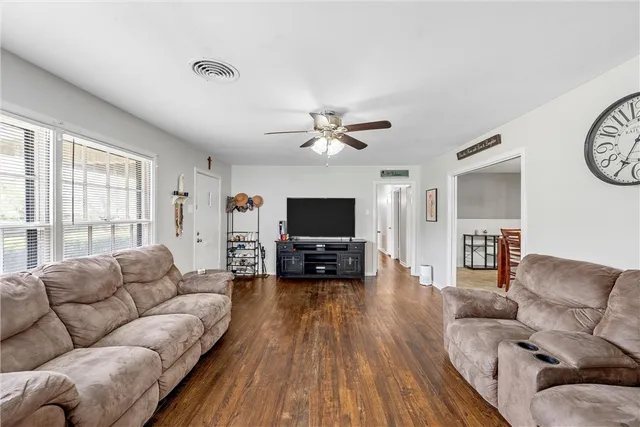 a living room with furniture and a flat screen tv with wooden floor
