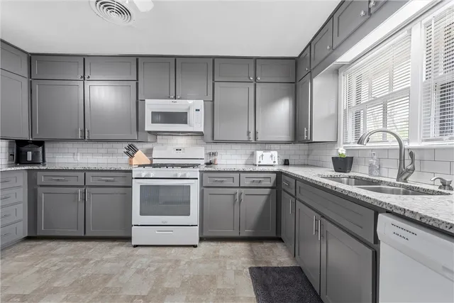 a kitchen with cabinets appliances a sink and a window