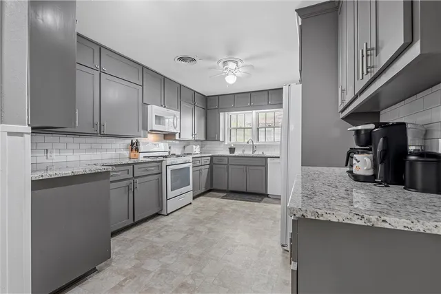 a kitchen with granite countertop a sink stainless steel appliances and cabinets