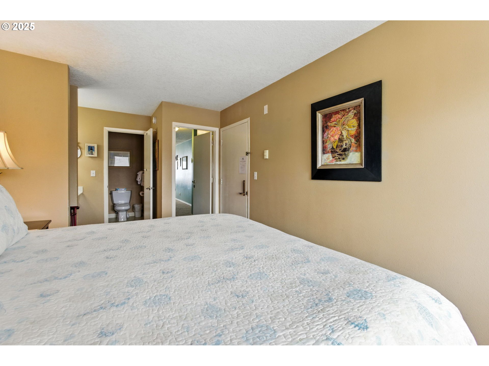 145 Northwest Inlet Avenue, Unit 217 Lincoln City, OR 97367 - Photo 20 of 28 a bedroom with a bed and a painting