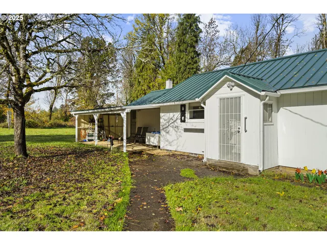 a backyard of a house with table and chairs