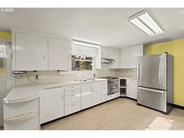 a kitchen with granite countertop white cabinets and white appliances