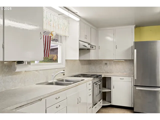 a kitchen with a sink a refrigerator and cabinets