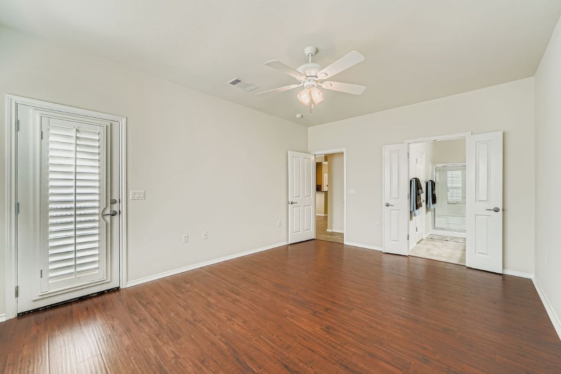 307 Mill Pond Path Georgetown, TX 78633 - Photo 16 of 26 Primary bedroom with dark wood-style floors, a ceiling fan, plantation shutters and ensuite bathroom