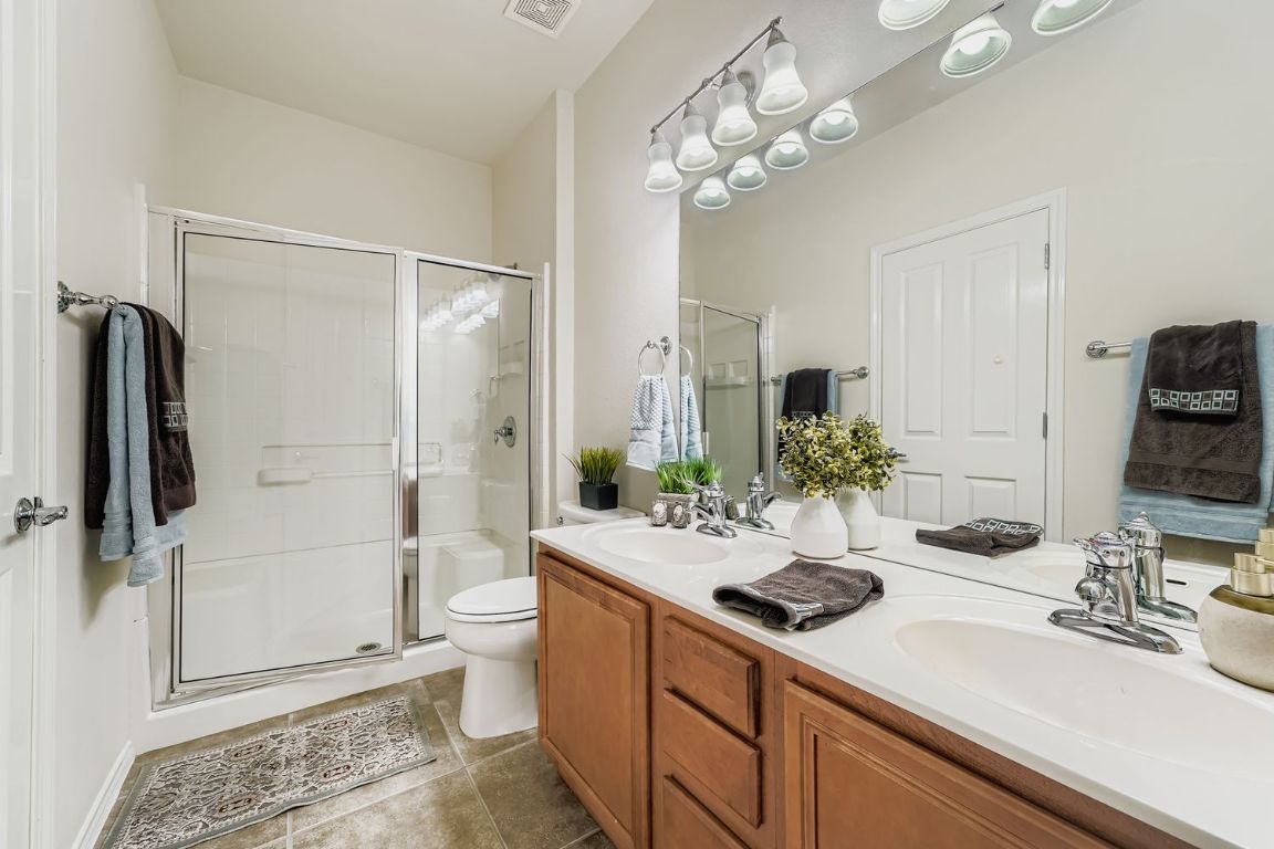 307 Mill Pond Path Georgetown, TX 78633 - Photo 17 of 26 Full bathroom featuring double vanity, a stall shower, and tile patterned floors